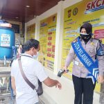 Petugas sedang mengecek suhu